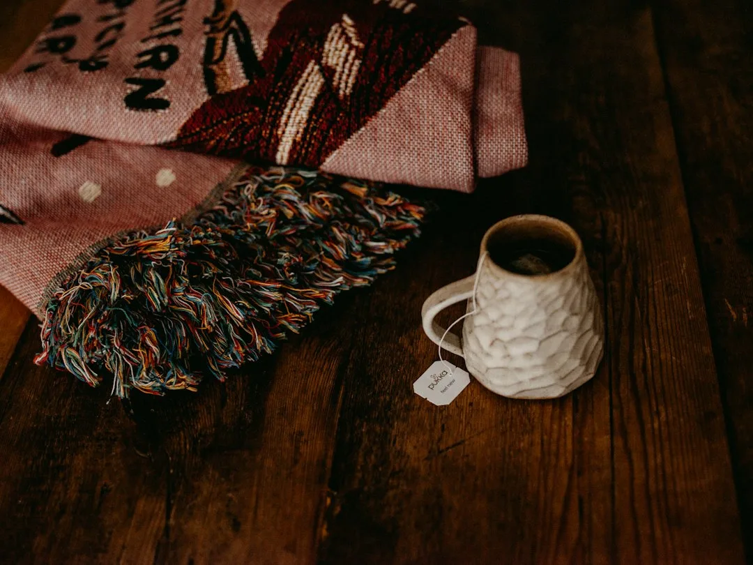 Warm socks, slippers, a blanket and a mug arranged for a cold day indoors