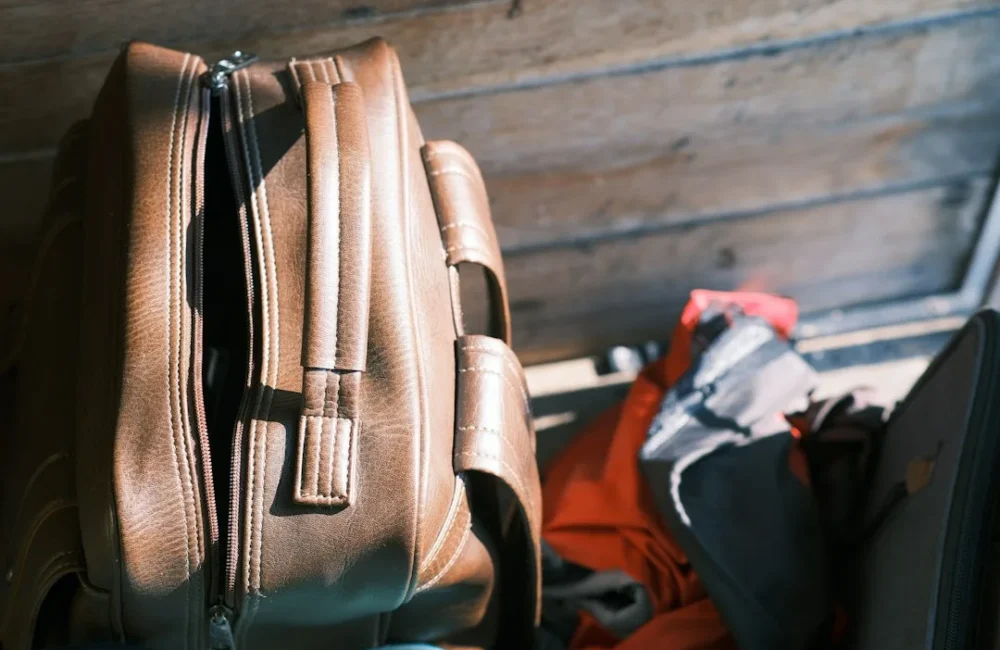 Compact travel accessories arranged beside an open carry-on bag