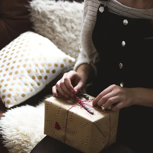 A man opening a thoughtful gift at a family celebration, illustrating the best gifts for a godfather