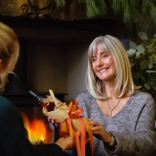 An older woman receiving a thoughtful gift at home, illustrating gifts for a mother-in-law who has everything