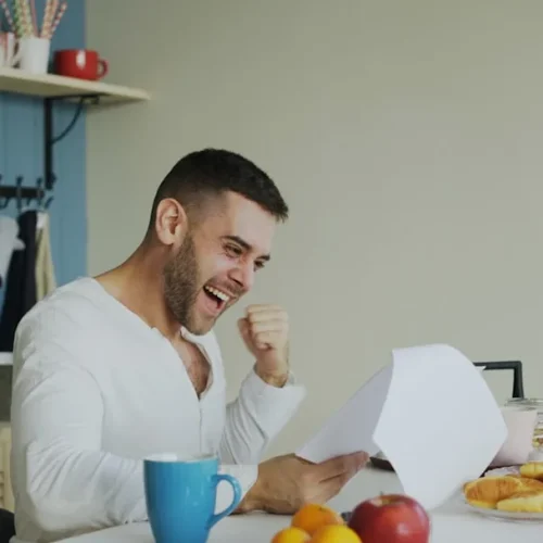 A man opening a gift at a family celebration, illustrating good gifts for a son-in-law