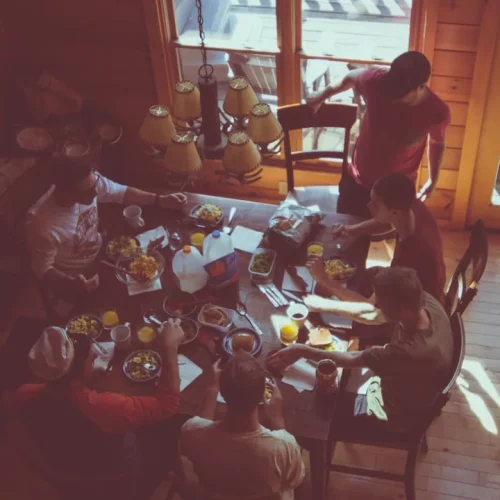 An older man opening a gift box at a family table, illustrating gifts for an uncle who is hard to shop for