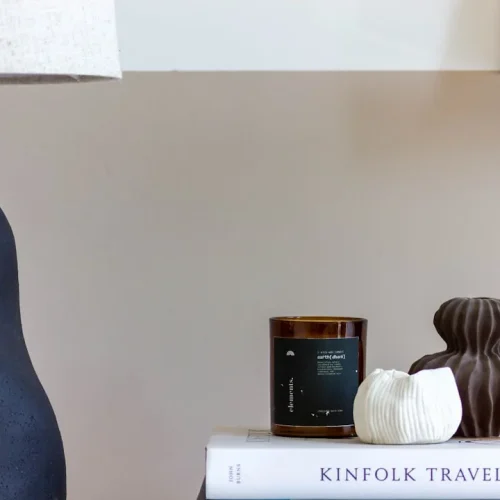 Curated cozy gift collection featuring merino wool bed socks, cashmere throw, and warm amber lighting on neutral background