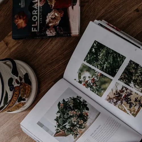 Curated selection of thoughtful gifts including linen journal, handmade ceramic mug, loose-leaf tea, and botanical print on neutral background