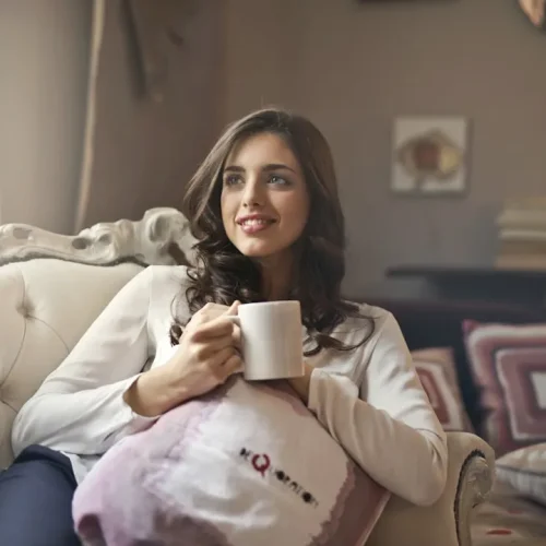 A new mother resting at home with a warm drink, illustrating gifts for your wife after becoming a mom