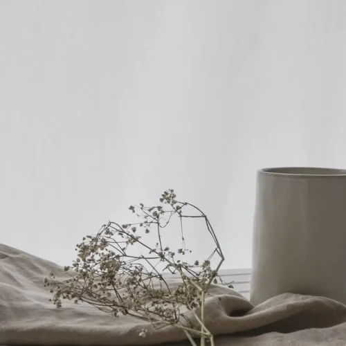 Thoughtfully curated gift arrangement for highly sensitive person featuring cashmere wrap, artisan ceramics, and natural elements in calming neutral tones