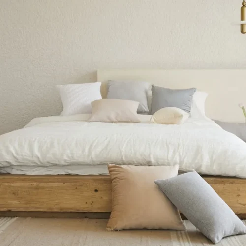 Serene minimalist bedroom sanctuary with natural wood diffuser, linen bedding, and soft ambient lighting creating a calm peaceful atmosphere