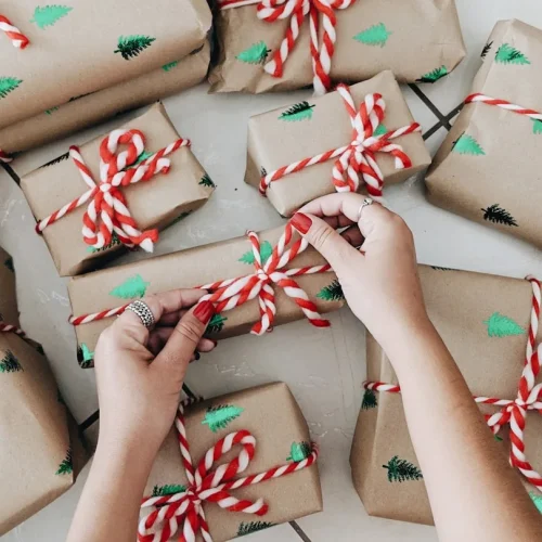 Person calmly wrapping a simple gift in neutral paper without stress