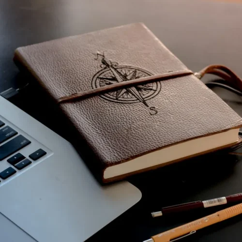 Collection of sentimental first anniversary gifts including leather journal, photo book, custom star map and memory box displayed on rustic wooden table