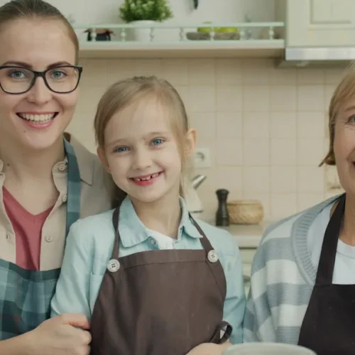 Grandmother receiving sentimental gifts from her grandchildren with emotional expressions of joy